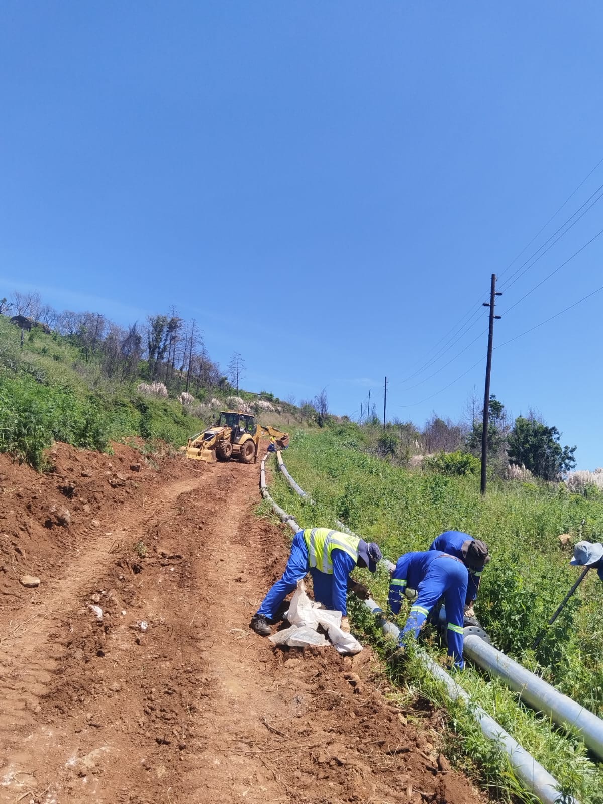 Wetpipe crew jointing slurry pipe on a hillside installation